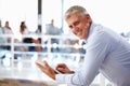 Portrait of middle aged man in office using tablet