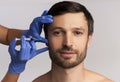 Portrait Of Middle-Aged Man Receiving Wrinkle-Removing Injection, White Background