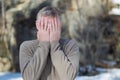 Portrait of a middle-aged man on the street, covering his face with his hands. Royalty Free Stock Photo