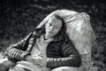 Portrait of a middle-aged man with a thin face in casual clothes sitting in a chair in the garden. Black and white Royalty Free Stock Photo