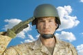 Portrait of middle-aged soldier in military uniform saluting against cloudy sky Royalty Free Stock Photo