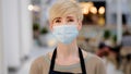 Portrait middle-aged woman adult lady cafe worker 40s female coffee shop owner waitress in protective medical face mask Royalty Free Stock Photo