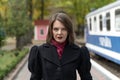 Portrait of middle-aged woman in black coat against of retro train. Aristocrat lady waiting for train on platform Royalty Free Stock Photo