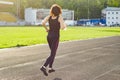 Portrait of middle aged woman running with bottle of water in the stadium, in evening. Copy space Royalty Free Stock Photo