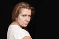 Portrait of a middle-aged woman with a serious sad face on a black background Royalty Free Stock Photo