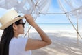 Portrait  middle shot view of woman stand in white T shirt and hat looking out towards blue ocean and sky, Women enjoy with Royalty Free Stock Photo