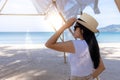 Portrait  middle shot view of woman stand in white T shirt and hat looking out towards blue ocean and sky, Women enjoy with Royalty Free Stock Photo