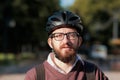 Portrait of a millennial commuter in a bicycle helmet. Safe cycling in the city, going to work on a bike, modern urban lifestyle