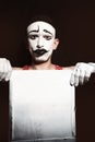 Portrait of mime holding white dirty sheet in hands