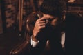 Portrait of minded handsome man in black suit having headache