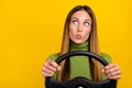 Portrait of minded lady pouted lips hold wheel look empty space isolated on yellow color background Royalty Free Stock Photo
