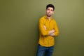 Portrait of minded pensive young man crossed arms look interested empty space brainstorming isolated on khaki color Royalty Free Stock Photo