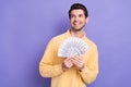 Portrait minded successful man hands hold dollar bills look interested empty space isolated on purple color background