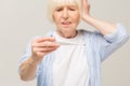 Portrait miserable, sick old woman with allergy, cold, blowing nose with paper tissue, isolated white background. Human face