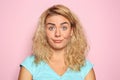 Portrait of mistrustful young woman on color background