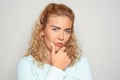 Portrait of mistrustful young woman on light background