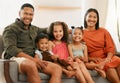 Portrait of a mixed race family of five relaxing on the sofa at home. Loving black family being affectionate on the sofa