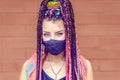 Portrait of mixed race girl with dreadlocks wearing protective face mask