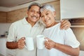 Portrait of mixed race senior couple enjoying morning coffee at home. Smiling elderly husband and wife standing together Royalty Free Stock Photo