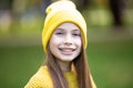 Portrait of modern happy teen girl with dental braces dressed in yellow clothes in park. Pretty teenage girl wearing