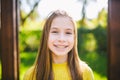 Portrait of modern happy teen girl with dental braces dressed in yellow clothes in park. Pretty teenage girl wearing