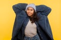 Portrait of modern happy trendy girl wearing warm winter hat and fur coat looking at camera with toothy smile Royalty Free Stock Photo