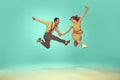 Portrait of modern jazz-dancers in mid-air against gradient mint background. Joyful dance partners performing dance Royalty Free Stock Photo