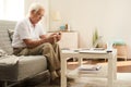 Senior Man Using Smartphone at Home