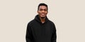 Portrait of modern smiling young african man looking at camera wearing black hoodie isolated on gray background Royalty Free Stock Photo