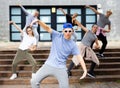 Modern teenager performing street dance with group