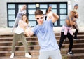Modern teenager performing street dance with group