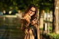 Portrait of modern woman using cell phone while walking through empty boulevard Royalty Free Stock Photo