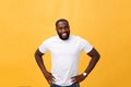 Portrait of a modern young black man smiling standing on isolated yellow background