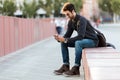 Modern young man using his mobile phone in the street. Royalty Free Stock Photo