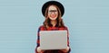 Portrait of modern young woman in casual working with laptop