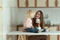 Portrait of mom and baby in kitchen. Happy young mom and toddler have breakfast at home