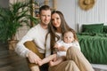 Portrait of Mom, Dad and six-month-old baby son in their arms spending time together in their cozy home Royalty Free Stock Photo