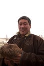 Portrait of a Mongolian herdsman with baby goat Royalty Free Stock Photo