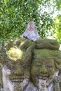 Portrait of a monkey sitting on a stone sculpture at sacred monkey forest in Ubud, island Bali, Indonesia . Closeup Royalty Free Stock Photo