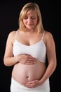 Portrait Of 5 months Pregnant Woman Wearing White On Black Background