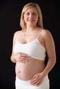 Portrait Of 5 months Pregnant Woman Wearing White On Black Background Royalty Free Stock Photo