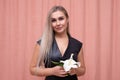 Portrait of the most beautiful girl with gorgeous smooth long hair with a flower in her hands on a pink background