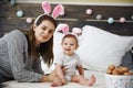 Portrait of mum and baby wearing rabbit costume in bed
