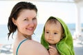 Portrait of a mother with a baby wrapped in a towel on a sea shore Royalty Free Stock Photo