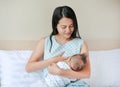 Portrait of mother breastfeeding her newborn child on the bed Royalty Free Stock Photo