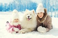 Portrait mother and child with white Samoyed dog together lying on snow in winter Royalty Free Stock Photo