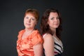 Portrait mother and daughter. Family portrait of two beautiful women of different ages in studio on black background. Royalty Free Stock Photo