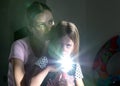 Portrait of mother and daughter. Little girl with a mirror, making a Sunny Bunny. Dark background Royalty Free Stock Photo