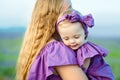 Mom keeps daughter in her arms and plays on the nature. Beautiful and happy mother with her little girl playing outdoors Royalty Free Stock Photo