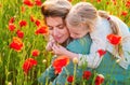 Portrait of mother and daughter walking through a flowering poppy field. Summer family holidays on nature. Summer on Royalty Free Stock Photo